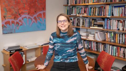 Jocelyn Viterna leaning against a table, smiling