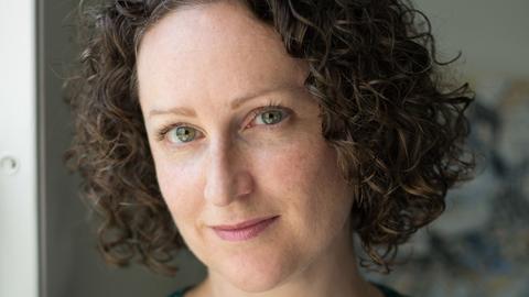 woman with short brown hair looking into the camera